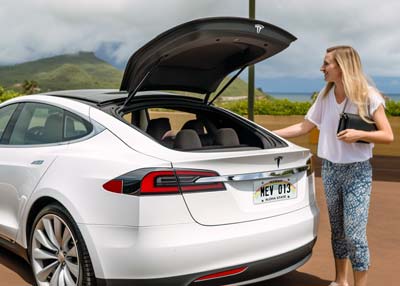 Woman admiring her Tesla rental on Maui